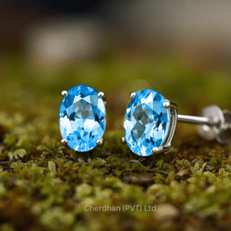 Close-up of a 1.2 carat three stone blue topaz matching stud earrings on a white background