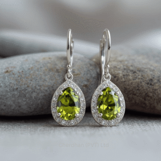 Macro shot focusing on the vibrant green, faceted peridot gemstone of a pear-shaped earring with shimmering halo of American diamonds.