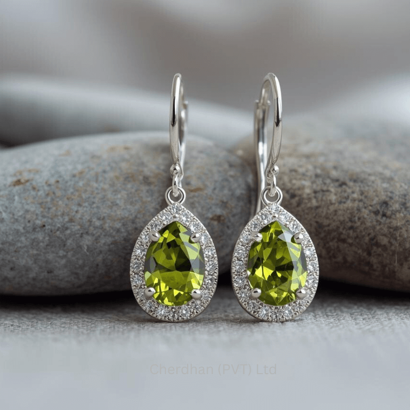 Macro shot focusing on the vibrant green, faceted peridot gemstone of a pear-shaped earring with shimmering halo of American diamonds.