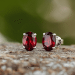 Elegant round-cut garnet stud earrings with silver setting