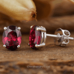 Close-up of natural garnet stud earrings set in 925 sterling silver